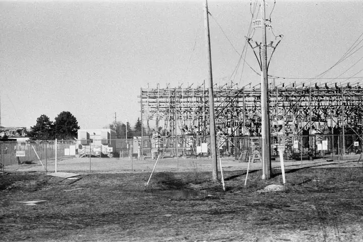 An electrical substation behind a chain-link fence